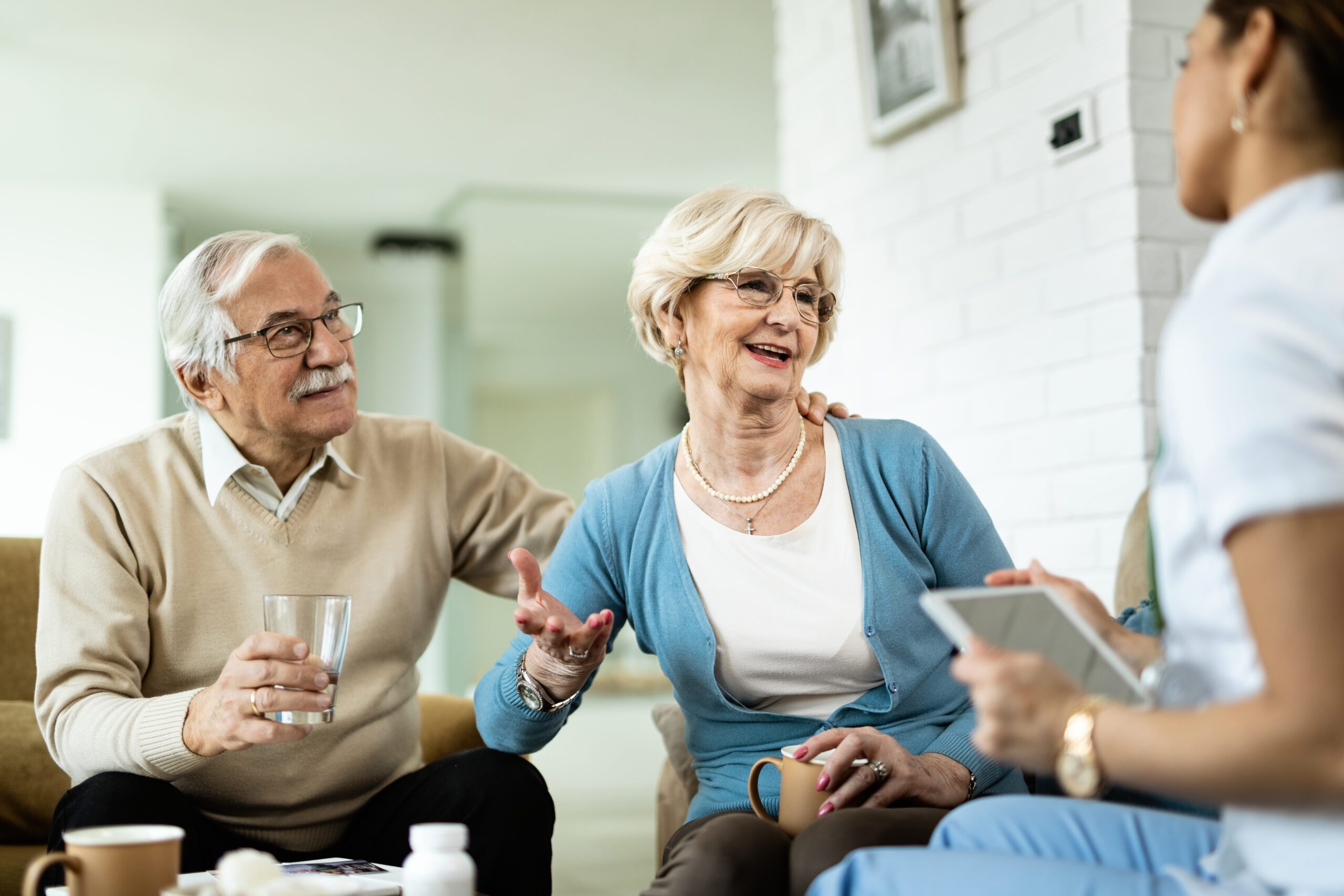 Happy senior couple talking to a property management during home visit.